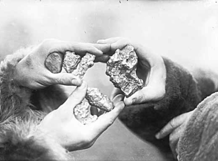 People with gold nuggets in hand, Yukon Territory.