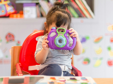 Toddler with plastic Camera