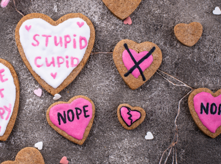 Heart shaped cookies decorated with words like NOPE and STUPID CUPID