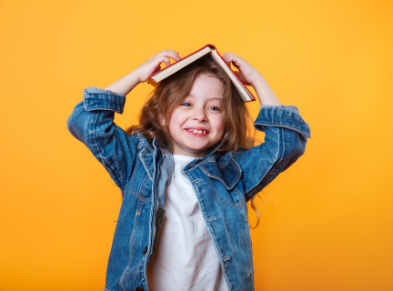 Child with a book open on their head.