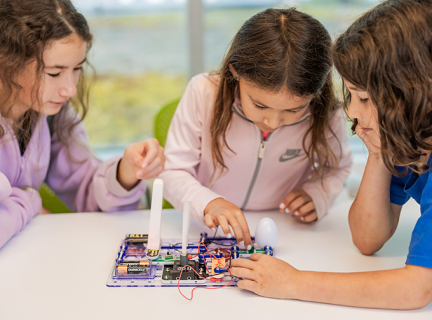 Kids play with a Snap Circuit kit