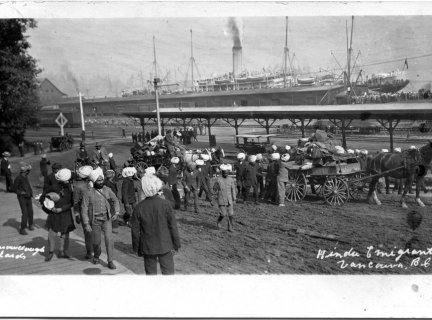 East Indian immigrants at the C.P.R. pier loading possessions onto horse drawn wagons