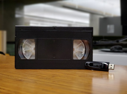 VHS tape and USB stick on table