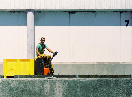 dock worker moving a yellow cargo box