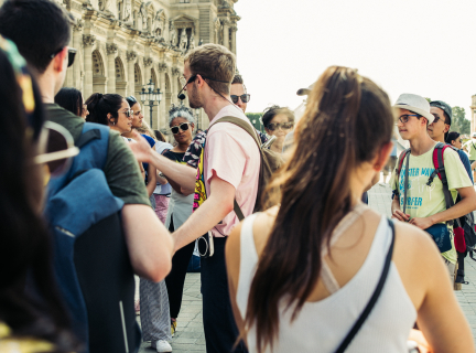 people on street during daytime standing around a tour guide