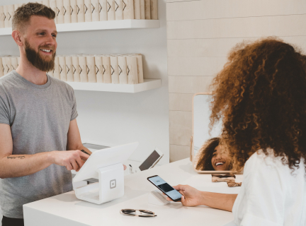 man in grey crew-neck t-shirt smiling to woman on counter