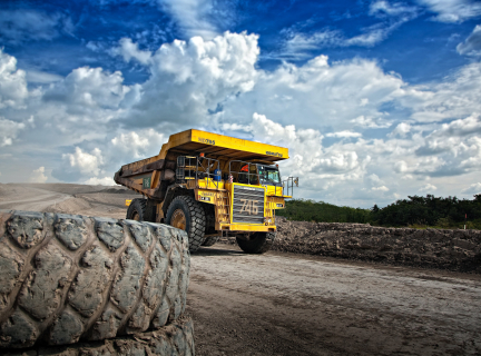 a very large dumptruck specifically used for mining driving along a quarry