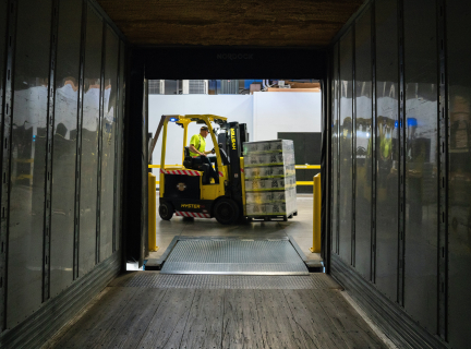 man carrying box using fork lift