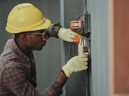 person in an orange safety helmet doing electrical work