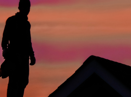 silhouette of a roofer standing on a roof