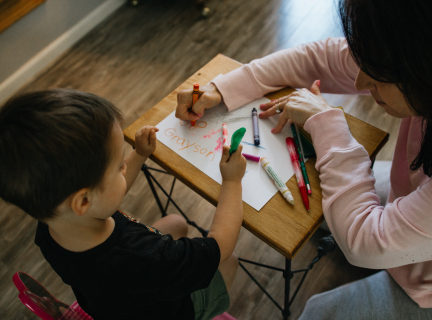 Photograph of a woman and child colouring together