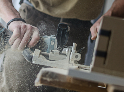 carpenter working with grey and blue power tools