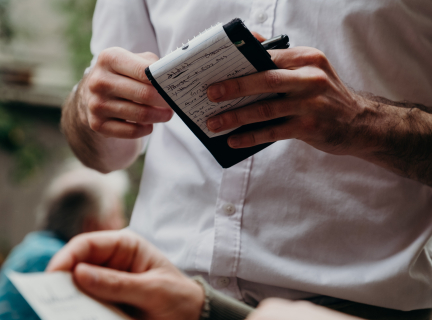 person wearing white taking an order from another person