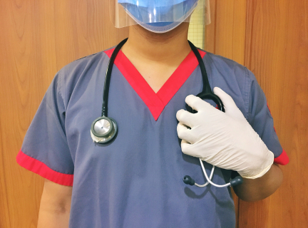 person in blue scrub suit wearing a mask