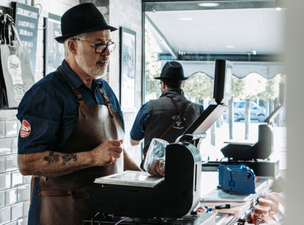 butcher weighing meat at a service counter