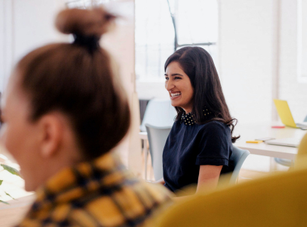 a smiling woman in a casual business meeting.