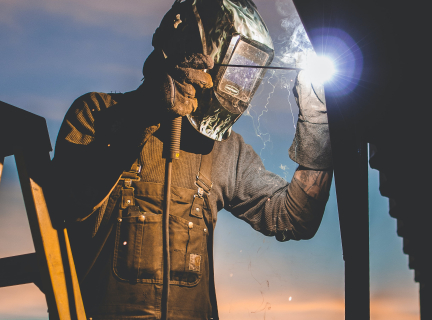 person standing on a ladder welding