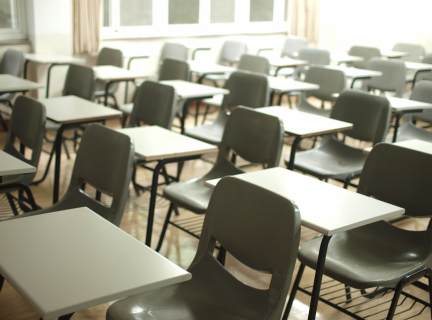 rows of empty classroom desks and chairs