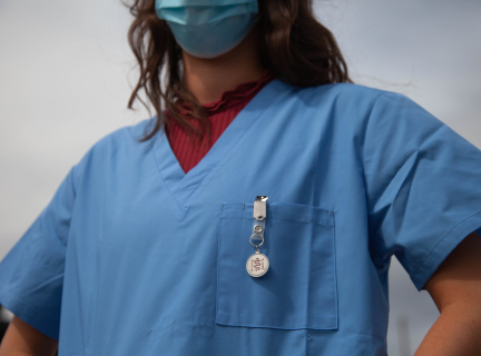 person in blue scrub suit wearing a mask