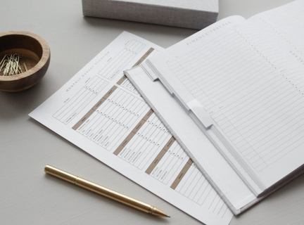 a record-keeping book on a table with a pen next to it