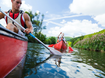 people paddling in canoes on a river