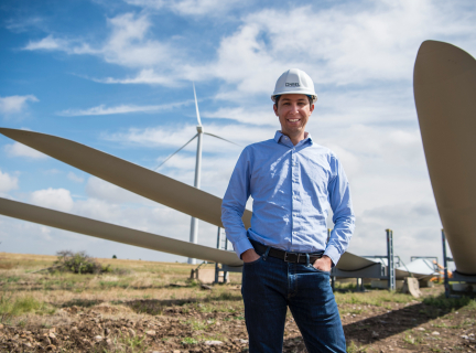 man smiling and standing near windmill