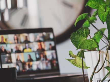 An image of an open laptop with people's faces on the screen