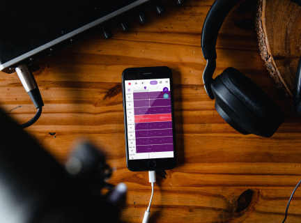 Mixer plugged into a phone with headphones recording audio