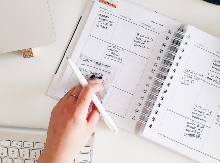 person holding notepad and pen flat lay photography