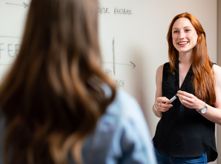 teacher standing in front of a white board