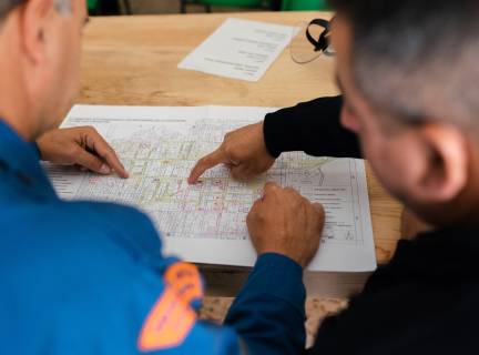 two people pointing to a technical drawing