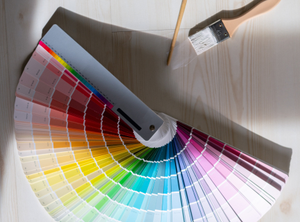 paint swatchs spread out on a table with two paint brushes nearby