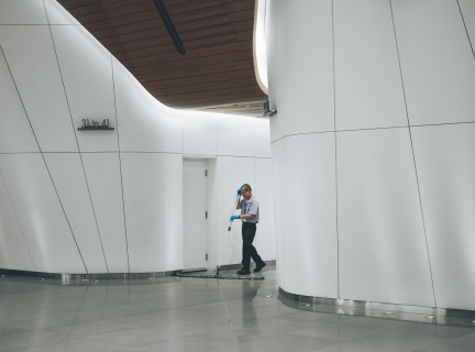 man cleaning on floor beside white wall