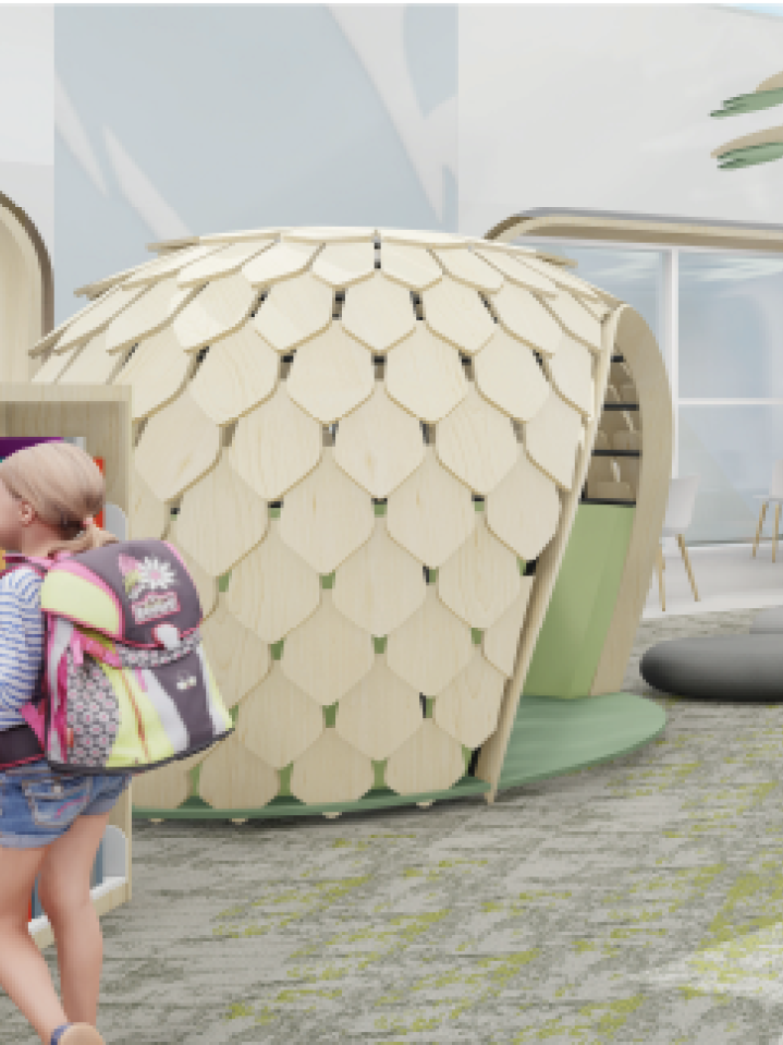 A kid-scale pod shaped somewhat like a pinecone with a large opening on the side. There are grey pebble-shaped seats on the ground and a child in a backpack looking at a bookshelf in the foreground.