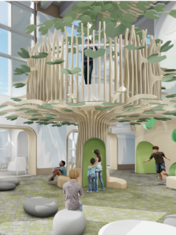 A computer rendering of a large tree-shaped indoor play structure. There are children and adults playing and interacting around it. Large pebble-shaped grey seats are scattered around it.