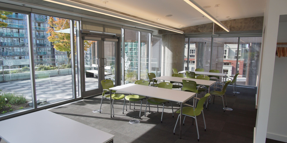 A photo of Room 910 with tables in pods