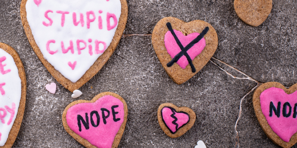 Heart shaped cookies decorated with words like NOPE and STUPID CUPID