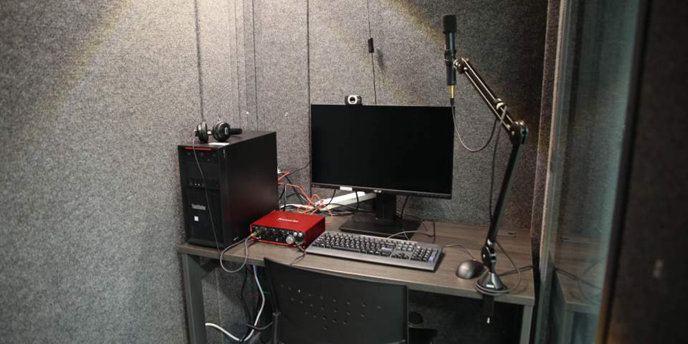 Sound booth with computer and microphone set up 